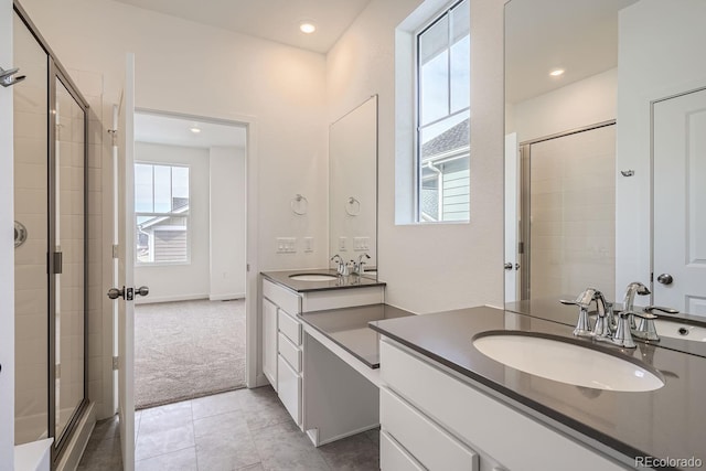 bathroom featuring a shower with door, vanity, tile patterned flooring, and a wealth of natural light