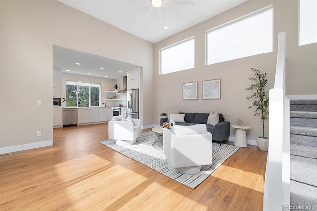 1340 W 68th Ave, Denver, CO 80221 - living area featuring ceiling fan, light wood-style flooring, stairway, a towering ceiling, and recessed lighting