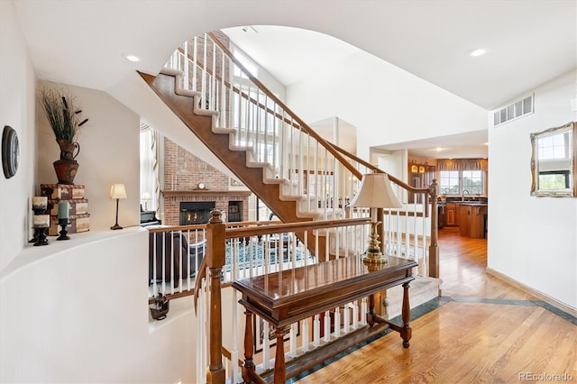 9416 Kemper Dr, Lone Tree, CO 80124 - stairway with wood finished floors, recessed lighting, lofted ceiling, arched walkways, and a fireplace