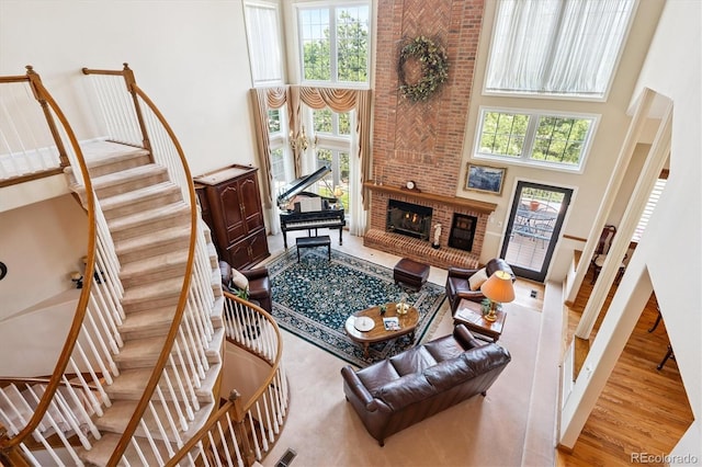 9416 Kemper Dr, Lone Tree, CO 80124 - living area featuring a high ceiling, healthy amount of natural light, wood finished floors, a fireplace, and stairs