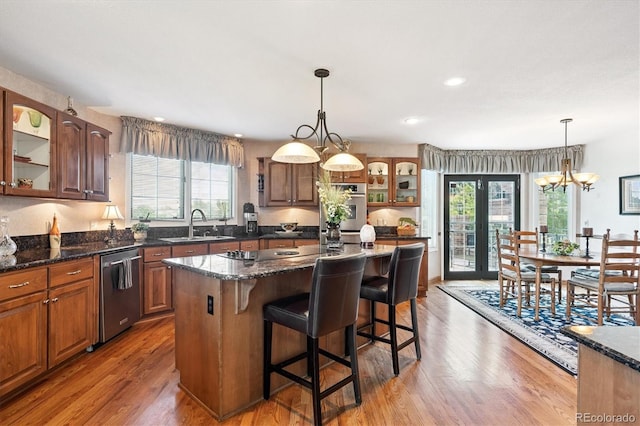 9416 Kemper Dr, Lone Tree, CO 80124 - kitchen with appliances with stainless steel finishes, light wood-style flooring, glass insert cabinets, a breakfast bar, and recessed lighting