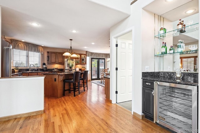 9416 Kemper Dr, Lone Tree, CO 80124 - indoor bar featuring beverage cooler, light wood-style flooring, recessed lighting, and hanging light fixtures