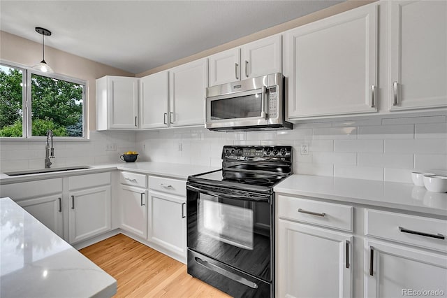 9717 Castle Ridge Cir, Highlands Ranch, CO 80129 - kitchen with stainless steel microwave, black / electric stove, white cabinetry, and decorative backsplash