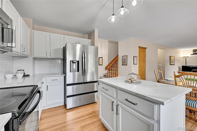 9717 Castle Ridge Cir, Highlands Ranch, CO 80129 - kitchen with stainless steel appliances, tasteful backsplash, light wood-type flooring, white cabinets, and a center island