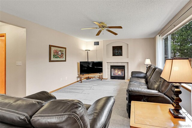 9717 Castle Ridge Cir, Highlands Ranch, CO 80129 - living room featuring a ceiling fan, carpet floors, a textured ceiling, and a tile fireplace