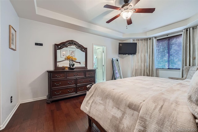 bedroom featuring ceiling fan, a raised ceiling, and dark hardwood / wood-style flooring