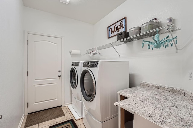 clothes washing area with light tile patterned floors and separate washer and dryer