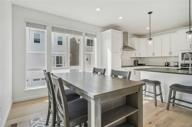 dining room with plenty of natural light, recessed lighting, light wood-type flooring, and baseboards