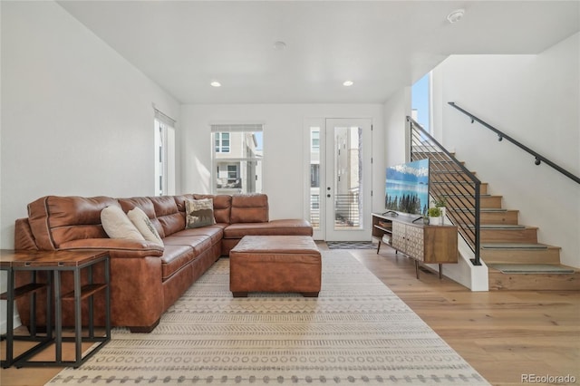 living room featuring recessed lighting, wood finished floors, and stairs