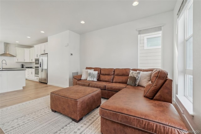 living area featuring recessed lighting, light wood-style flooring, and baseboards