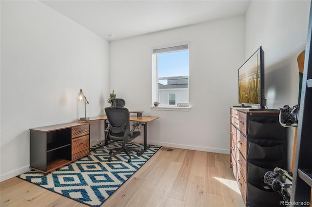 office with visible vents, baseboards, and wood finished floors