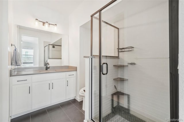 bathroom with tile patterned floors, vanity, a shower stall, and toilet