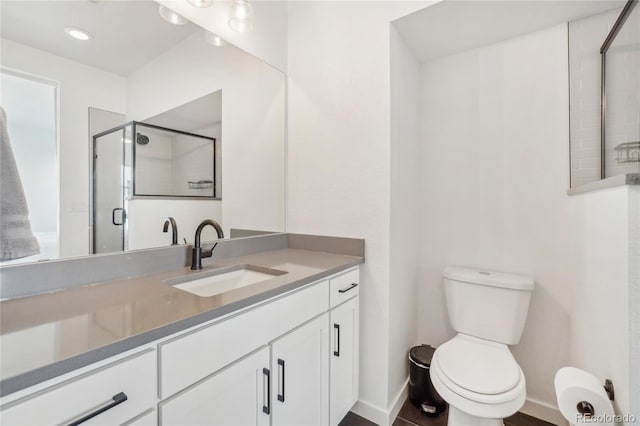 full bathroom with a stall shower, toilet, vanity, and baseboards