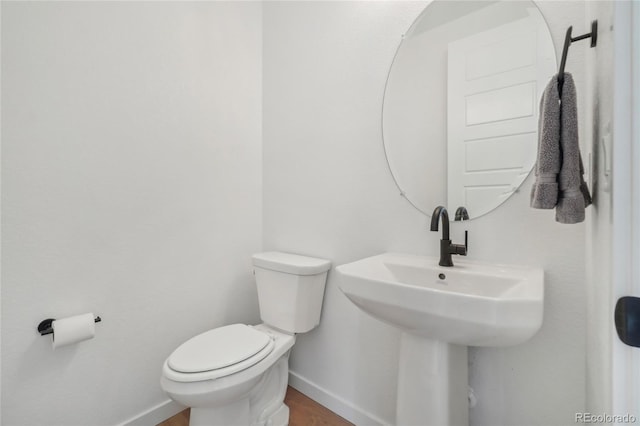 bathroom featuring baseboards and toilet