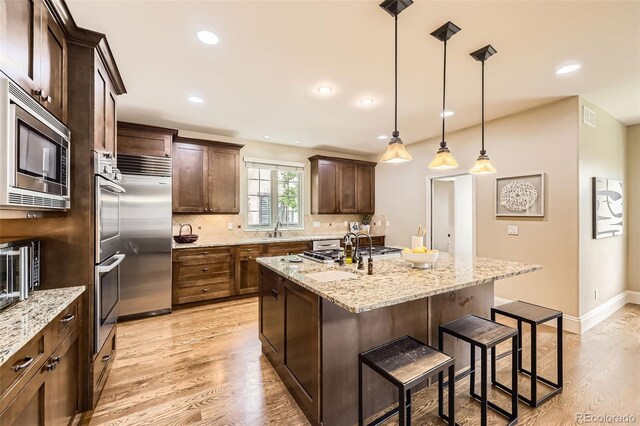 1410 S Elizabeth St, Denver, CO 80210 - kitchen with built in appliances, a sink, a kitchen breakfast bar, backsplash, and recessed lighting