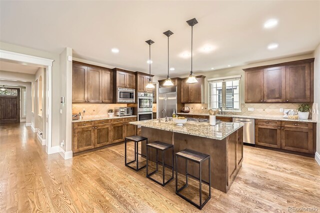 1410 S Elizabeth St, Denver, CO 80210 - kitchen featuring built in appliances, light wood-style flooring, a kitchen bar, a sink, and recessed lighting