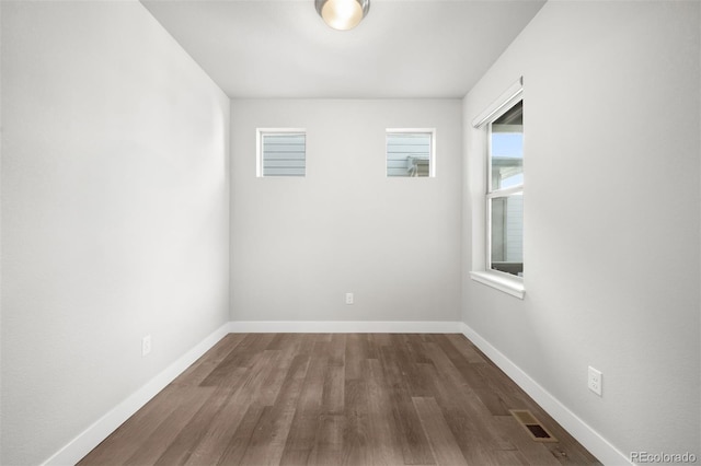 unfurnished room with dark wood-type flooring