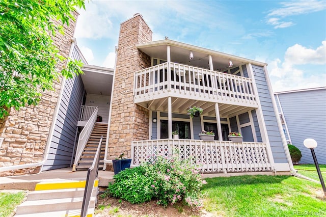 8335 Fairmount Dr Unit 10-208, Denver, CO 80247 - view of front of house featuring a balcony, covered porch, and stone siding