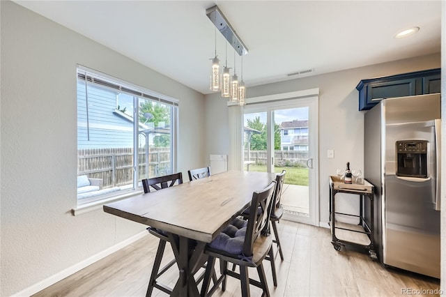 dining area featuring a wealth of natural light, a notable chandelier, and light hardwood / wood-style floors