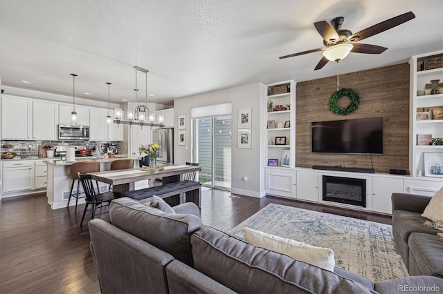 6834 Clay St N, Denver, CO 80221 - living area featuring ceiling fan, dark wood finished floors, a chandelier, and built in shelves