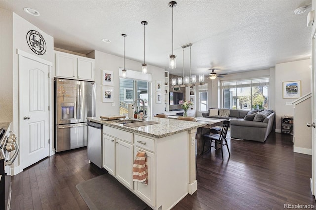 6834 Clay St N, Denver, CO 80221 - kitchen with stainless steel appliances, dark wood-style flooring, open floor plan, a textured ceiling, and ceiling fan