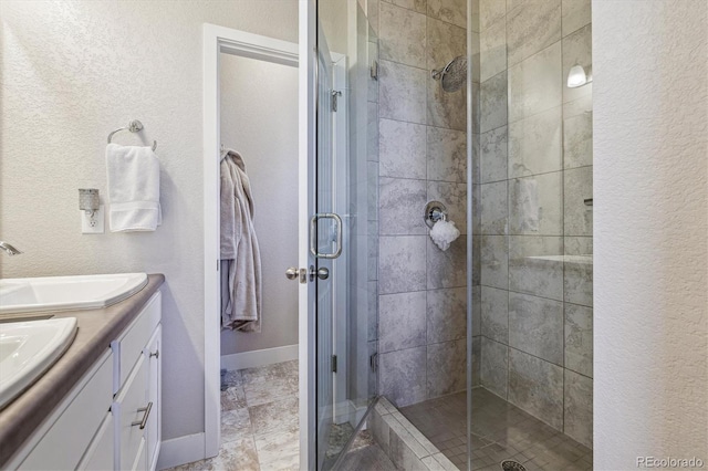 6834 Clay St N, Denver, CO 80221 - full bathroom featuring a shower stall, double vanity, and a textured wall