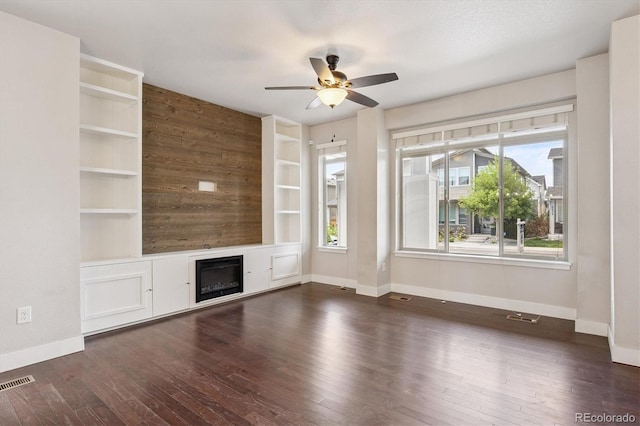 6834 Clay St N, Denver, CO 80221 - unfurnished living room with a ceiling fan, dark wood-style floors, a glass covered fireplace, and built in shelves