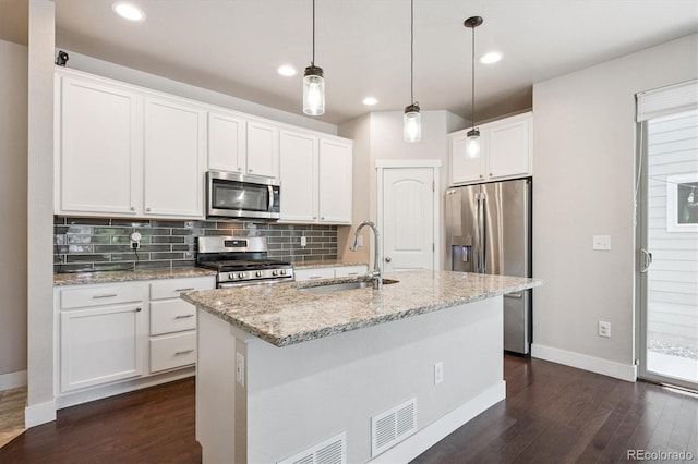 6834 Clay St N, Denver, CO 80221 - kitchen featuring stainless steel appliances, dark wood-type flooring, white cabinetry, decorative backsplash, and pendant lighting