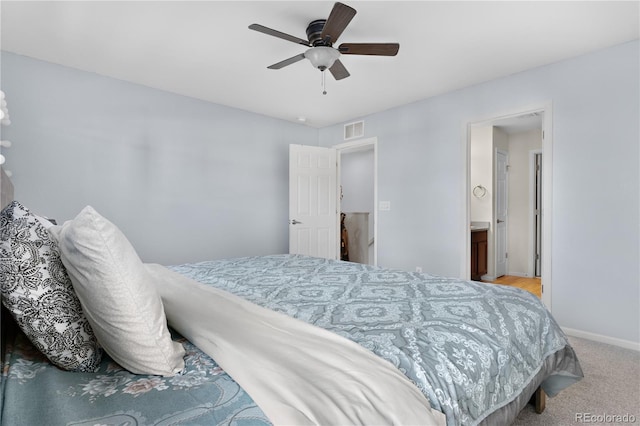 carpeted bedroom with ceiling fan and ensuite bathroom