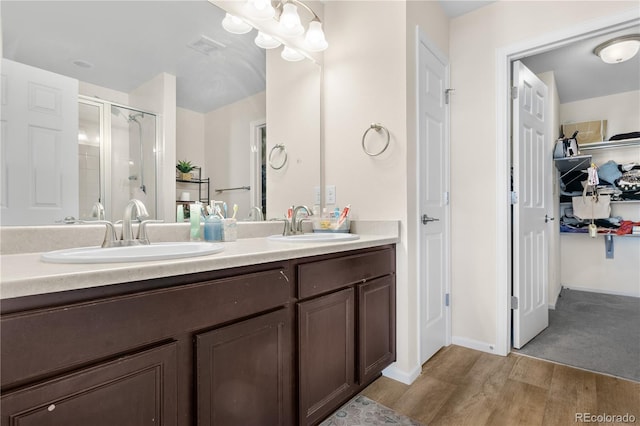 bathroom with hardwood / wood-style floors, vanity, and an enclosed shower