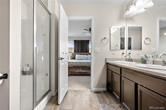 bathroom featuring walk in shower, hardwood / wood-style floors, vanity, and ceiling fan