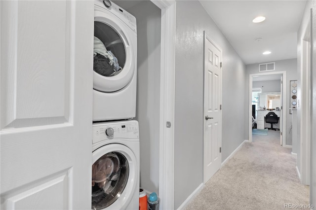 laundry room with light carpet and stacked washer and clothes dryer