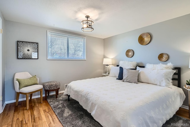 bedroom with baseboards and wood finished floors