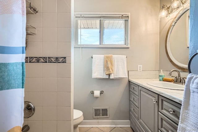 bathroom featuring vanity, visible vents, baseboards, tile patterned flooring, and toilet