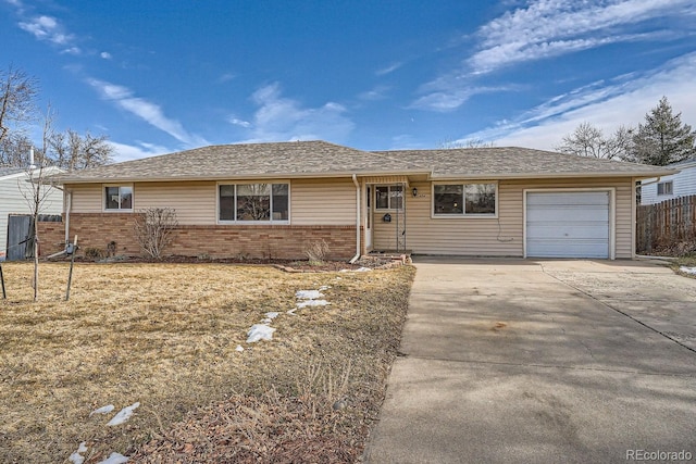 ranch-style home with concrete driveway, an attached garage, fence, and brick siding