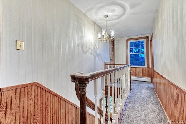 hallway featuring carpet, a baseboard heating unit, and a chandelier