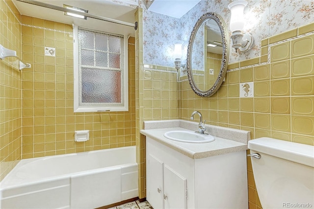 full bathroom featuring tile walls, tiled shower / bath combo, toilet, and vanity