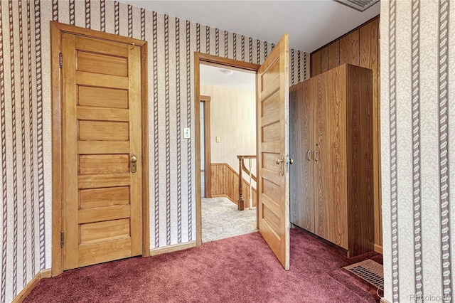 interior space featuring carpet and wooden walls