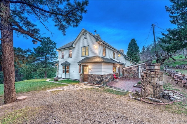 view of front of house with a patio and a front lawn