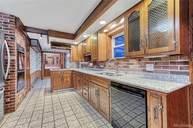 kitchen with black appliances, sink, light stone counters, light tile patterned floors, and backsplash