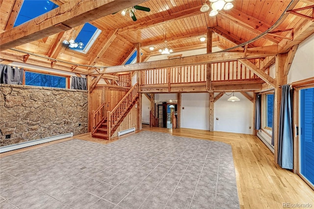 unfurnished living room featuring beamed ceiling, light tile patterned floors, a skylight, wooden ceiling, and baseboard heating