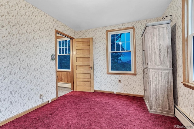 unfurnished bedroom with a baseboard heating unit and carpet floors