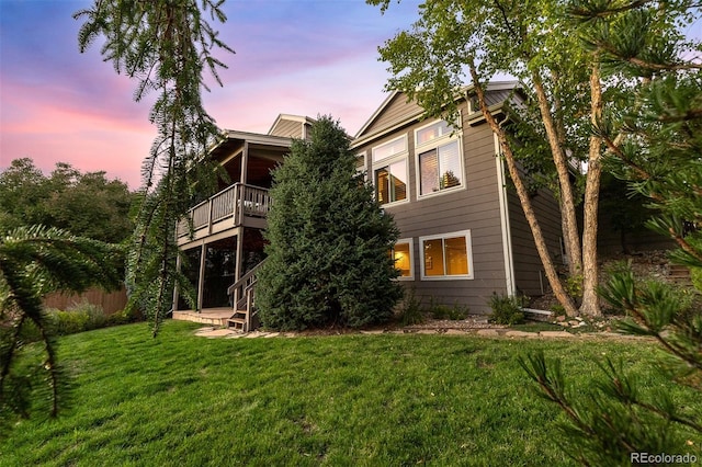 rear view of property with a lawn and stairs