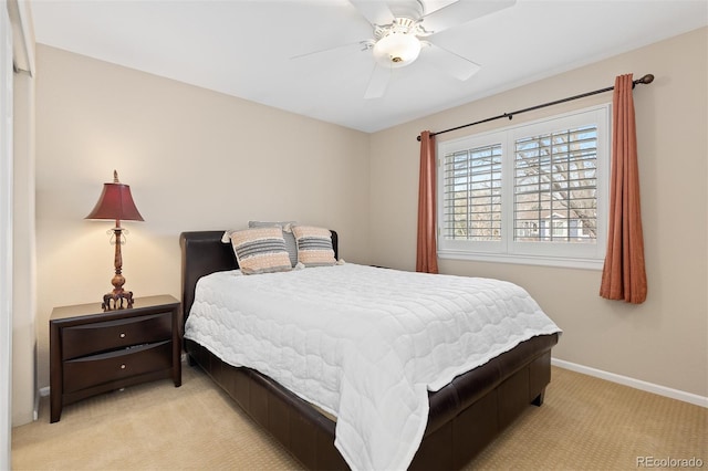 bedroom with a ceiling fan, light carpet, and baseboards