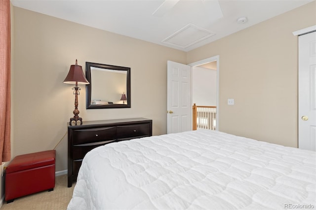 carpeted bedroom featuring attic access and ceiling fan