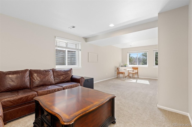 living area with light carpet, baseboards, and visible vents