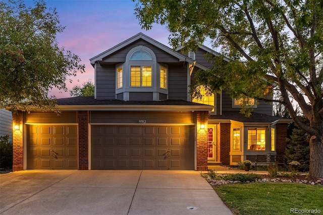 traditional-style home featuring driveway, brick siding, and an attached garage