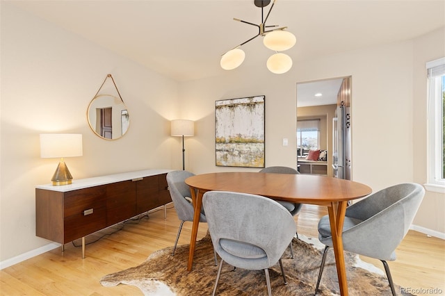 dining room featuring light wood finished floors and baseboards