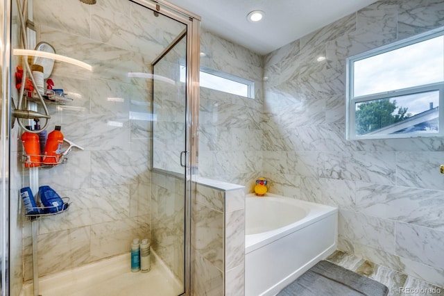 bathroom featuring a shower stall, a bath, and recessed lighting