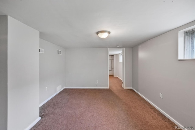 carpeted empty room featuring baseboards